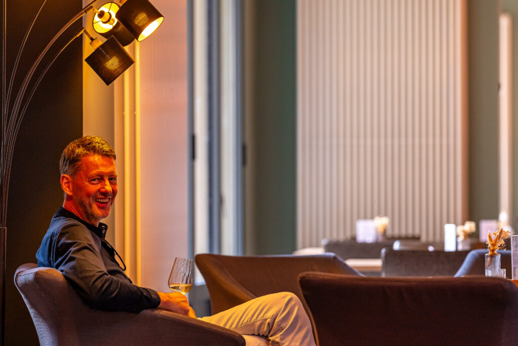 Daily am Dom - Inhaber Jörg Siersleben mit Glas Wein, lachend