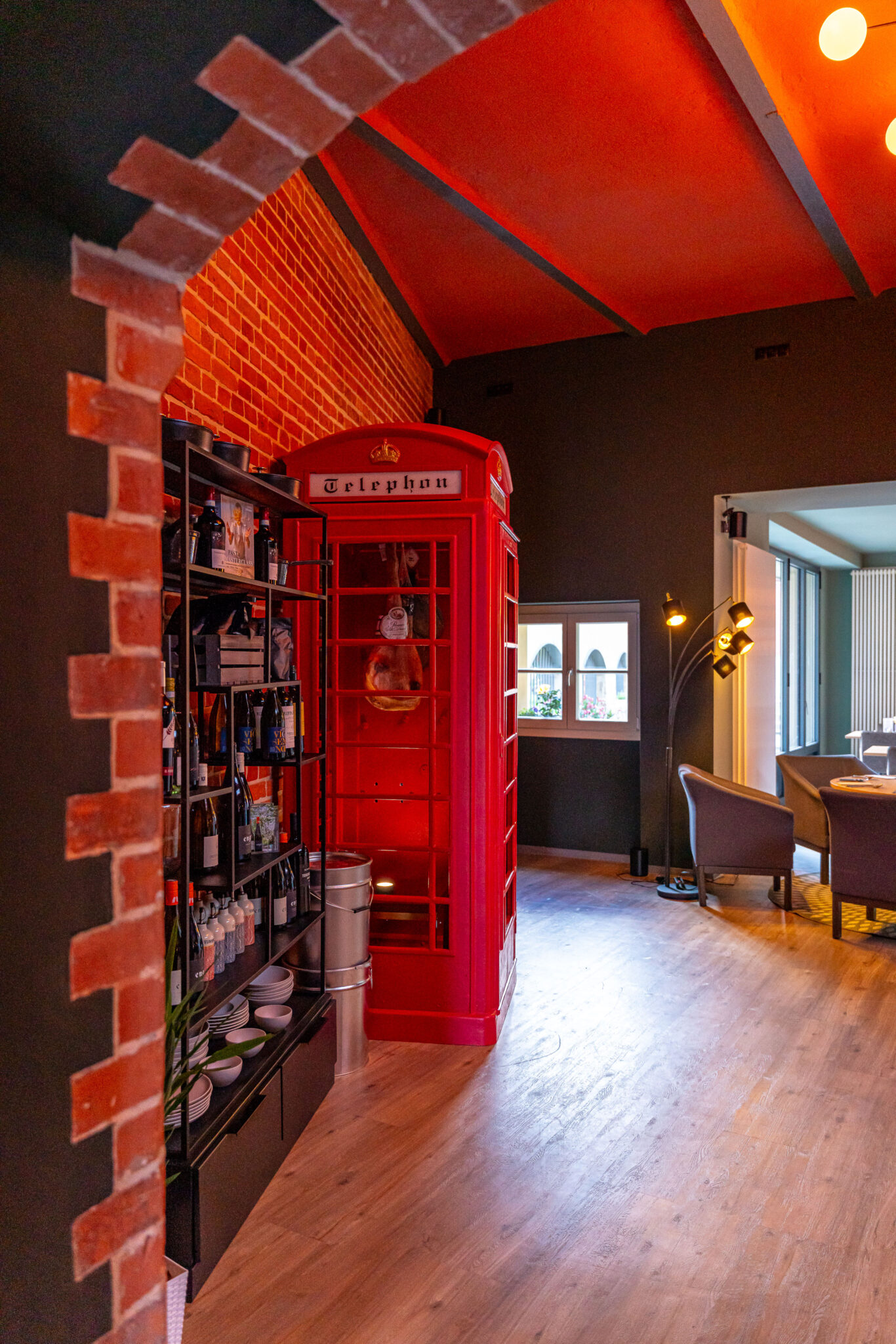 Restaurantbereich mit Weinen und alte Telefonzelle mit Räucherware